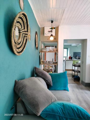 un salon avec un canapé et un mur bleu dans l'établissement home edwige, à Fresse