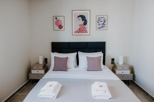 a bedroom with a bed with two towels on it at Pearl Apartel in Volos