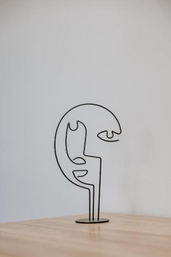 a metal sculpture of a man on a table at Pearl Apartel in Volos