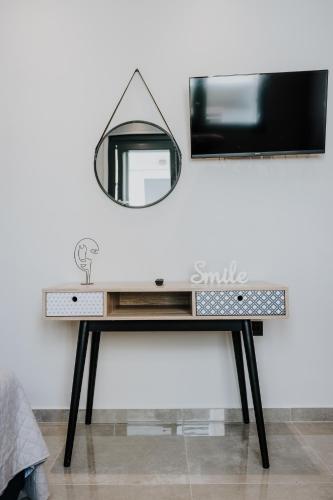 a dressing table with a mirror on a wall at Pearl Apartel in Volos