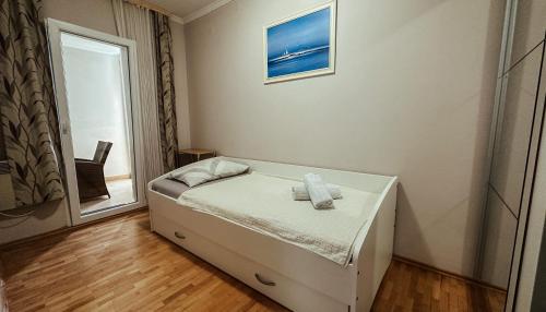 ein kleines Schlafzimmer mit einem Bett und einem Fenster in der Unterkunft Apartmani JELENA Opatija in Opatija