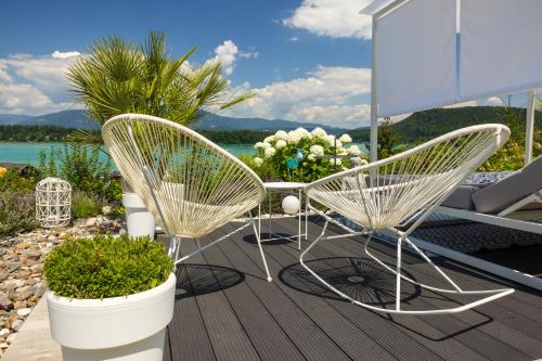 two chairs and a table on a deck at Lakeside Apartments - Adults Only in Faak am See