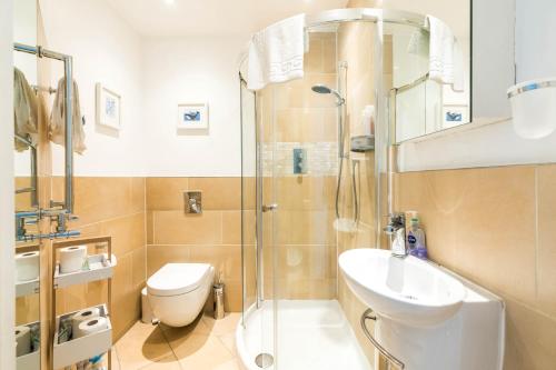 een badkamer met een douche, een toilet en een wastafel bij Spacious 2 bedroom / Gloucester Road / Kensington in Londen