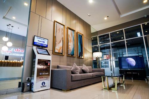 eine Lobby mit einem Sofa und einem TV in einem Gebäude in der Unterkunft Modern Designed Studio Condo Near Ayala Centrio in Cagayan de Oro