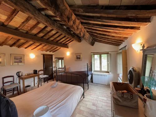 Un dormitorio con una cama grande en una habitación con techos de madera. en Casa Al Fondo, en Gualdo di Macerata