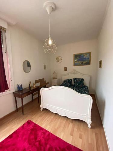 - un salon avec un lit blanc et un tapis rouge dans l'établissement Petit T2 proche centre et stade tribut Dunkerque, à Dunkerque