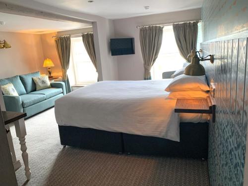 a bedroom with a large bed and a couch at The Bay Horse, Masham in Masham