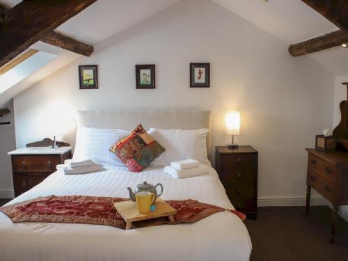 Un dormitorio con una cama blanca y una bandeja. en Pass the Keys Heart of Llandovery Large 4BR Apartment For 9, en Llandovery