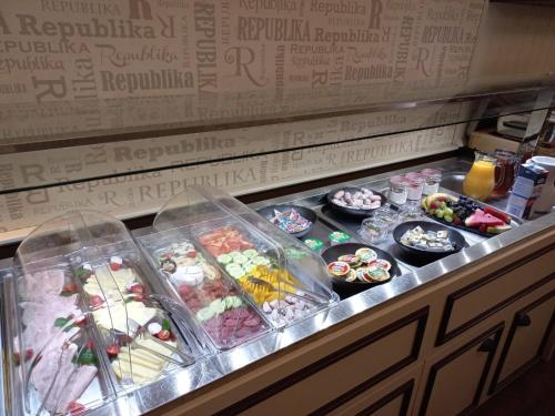 a buffet line with many different types of food at Wellness Hotel Republika 24 Apartments in Plzeň