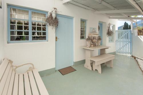 un porche con banco y puerta azul en The Lady Grace en Greyton
