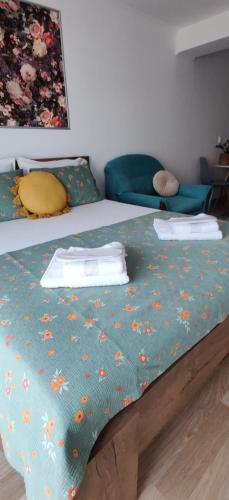 a bed with a green blanket with flowers on it at Flowers in the Center in Oradea