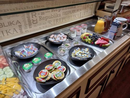 a buffet line with many different types of food at Wellness Hotel Republika 24 Apartments in Plzeň