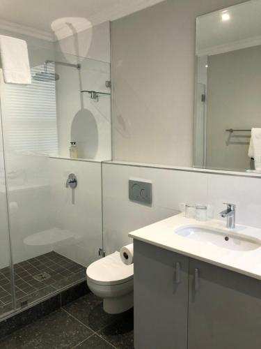 a bathroom with a toilet and a sink and a shower at Romney Park Luxury Apartments by The Stay Collection in Cape Town