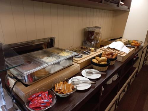 a kitchen with a buffet with bread and pastries at Wellness Hotel Republika 24 Apartments in Plzeň