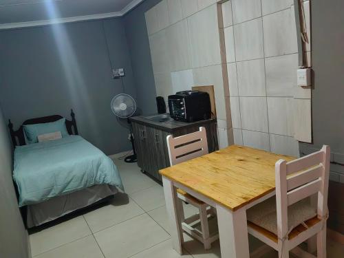 Habitación pequeña con mesa y cama en Good and Proper Guest Lodge, en Vereeniging
