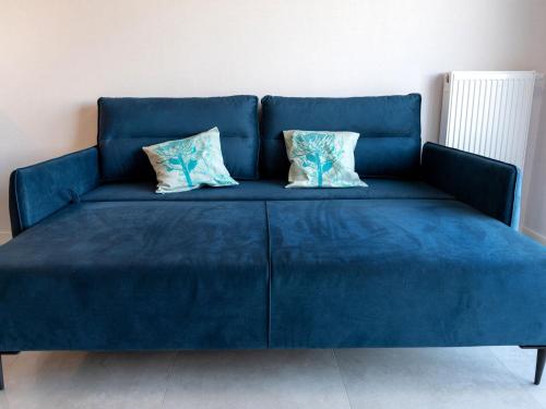 a blue couch with two pillows on it at Duplex holiday apartment Rewal in Rewal