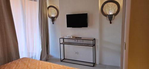 een slaapkamer met een televisie aan de muur en een bed bij Green Park Hotel in Porto Cervo