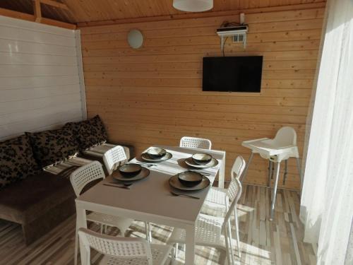 a living room with a table and chairs and a television at Cottage for 4 people Ustronie Morskie in Ustronie Morskie