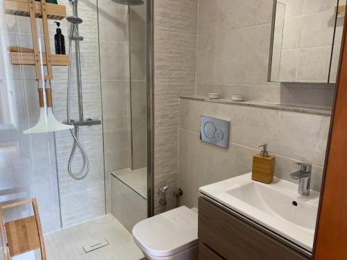 een badkamer met een douche, een wastafel en een toilet bij MAGNIFICO CHALET UNICO JUNTO AL MAR CALETA DE VELEZ in Caleta De Velez