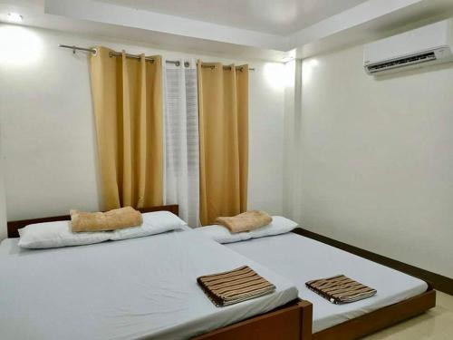 1 dormitorio con 2 camas y toallas. en Charls Place - Private Villa with Pool for up to 20pax, en Sablayan