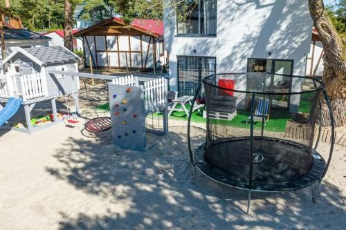 a playground with a slide and a swing set at Cottage near the beach for 3 people in Pustkowo in Pustkowo