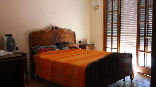 1 dormitorio con 1 cama grande con manta naranja en Room in Villa - Hillside room with garden and sea view, en San Salvatore