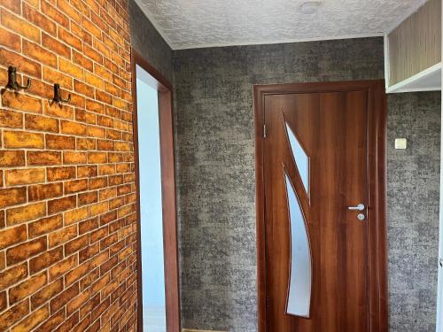 um quarto com uma parede de tijolos e uma porta de madeira em Viesite em Viesīte