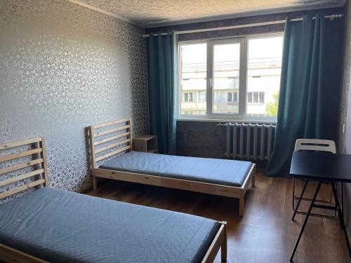 1 dormitorio con 2 camas y ventana en Viesite, en Viesīte