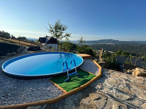 a swimming pool sitting on top of a hill at Dom pod kogutem in Laliki