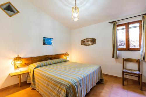 - une chambre avec un lit, un bureau et une chaise dans l'établissement Residence Praia di Fuoco, à Capo Vaticano