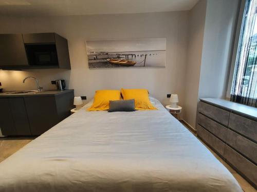 een groot bed met 2 gele kussens in een kamer bij A bon port in Aix-les-Bains