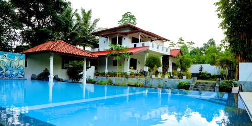 a villa with a swimming pool in front of a house at Villana Villa Bentota in Bentota