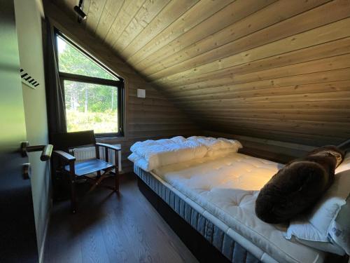 Cama grande en habitación con techo de madera en Skarvruetstugan Funäsdalen en Tänndalen