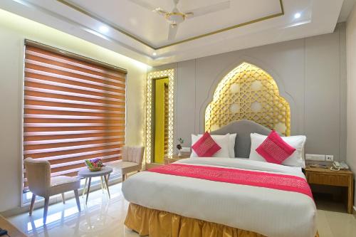 a bedroom with a large bed with red and yellow pillows at Hotel Gold Palace - 03 Mins Walk From New Delhi Railway Station in New Delhi