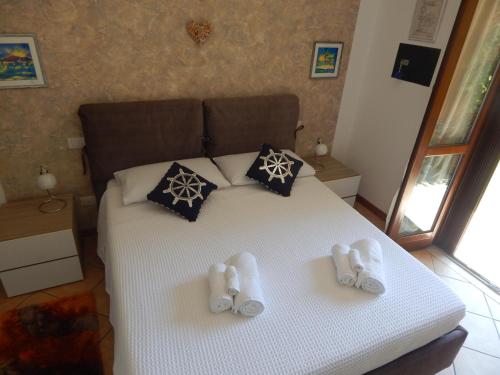 a bedroom with a bed with slippers on it at IL TIMONE DI PACENGO in Pacengo di Lazise