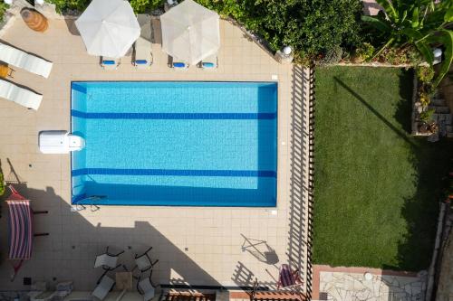 - une vue sur la piscine dans la cour dans l'établissement Villa Satra, à Elefterna