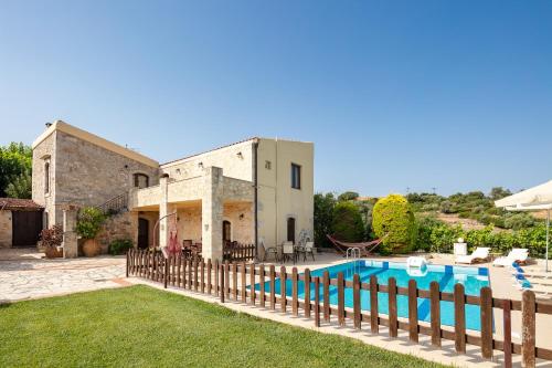 an external view of a house with a swimming pool at Villa Satra in Elefterna