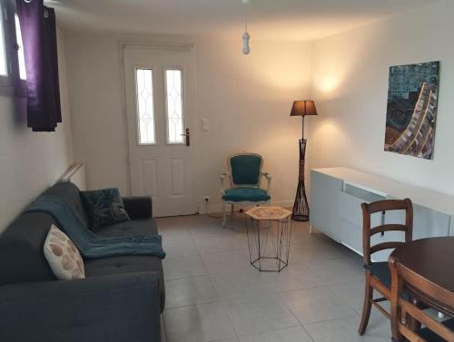 un salon avec un canapé, des chaises et une table dans l'établissement logement pour la famille, à Orvault