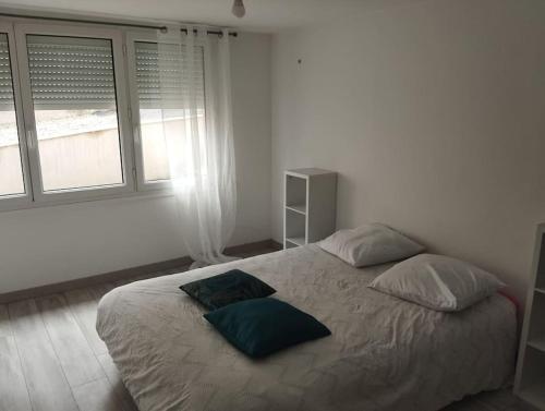 une chambre avec un lit avec deux oreillers dessus dans l'établissement logement pour la famille, à Orvault