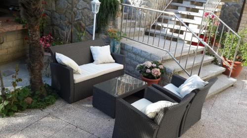 a patio with two chairs and a table and stairs at Rooms Vukušić in Rab