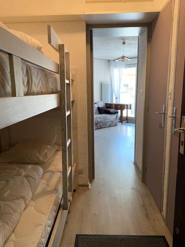 une chambre avec des lits superposés et un couloir avec un salon dans l'établissement Appartement Centre station - Les Deux Alpes, à Les Deux Alpes