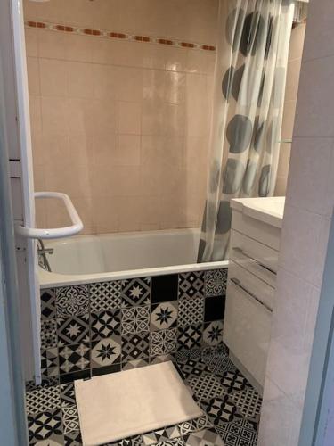 La salle de bains est pourvue d'une baignoire et de carrelage. dans l'établissement Appartement Centre station - Les Deux Alpes, à Les Deux Alpes