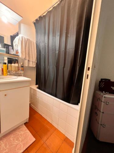 a bathroom with a shower with a black shower curtain at Abreu in Lyon