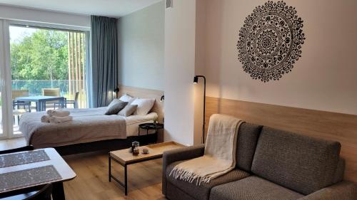 a hotel room with a bed and a couch at Apartament Laguna Beskidów 57 Góry i Jezioro - Dream Apart in Zarzecze