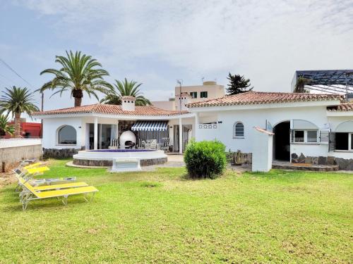 埃爾紹薩爾的住宿－Villa Don Antonio，白色的房子,有黄色长凳的院子