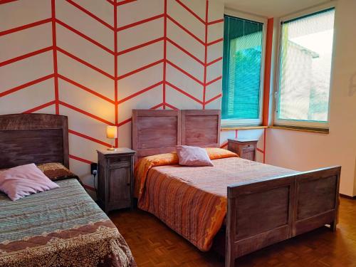 a bedroom with two beds and a striped wall at B&B Colorado in Bergamo