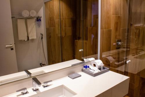 a bathroom with a sink and a large mirror at Hotel Senac Ilha do Boi in Vitória