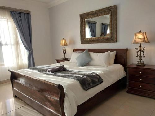 una camera con un grande letto e uno specchio di Kloof a Pretoria