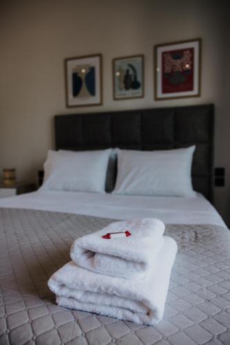 a pile of towels sitting on top of a bed at Pearl Apartel in Volos