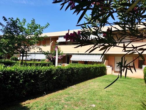 a building with a hedge in front of a building at ISA-Holiday Homes in Marina di Bibbona from 400 to 900 m from the beach, apartments 6 beds with private outdoor area in Marina di Bibbona